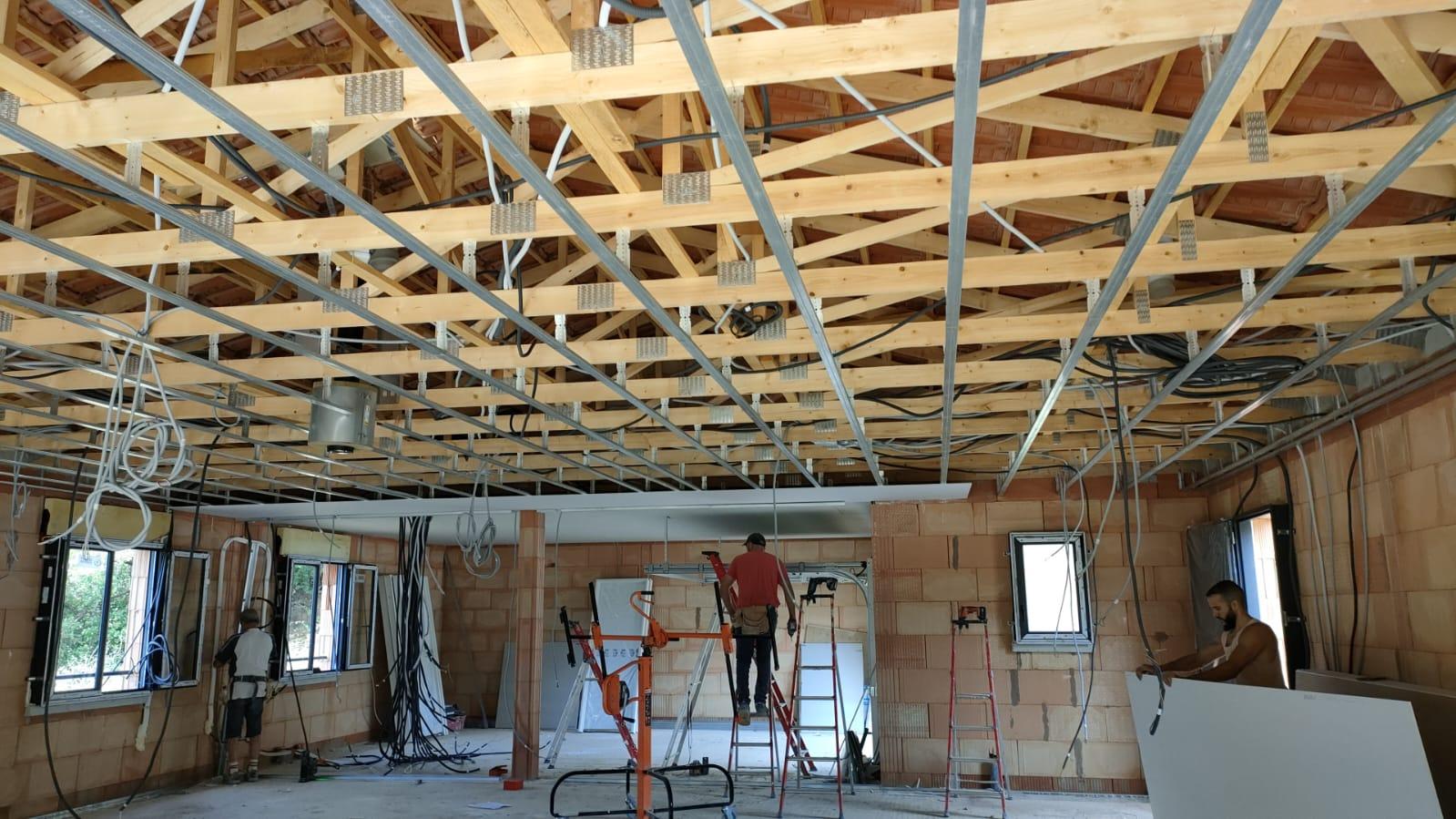 Ossature métallique d'un faux plafond en cours de réalisation sur un chantier de plâtrerie