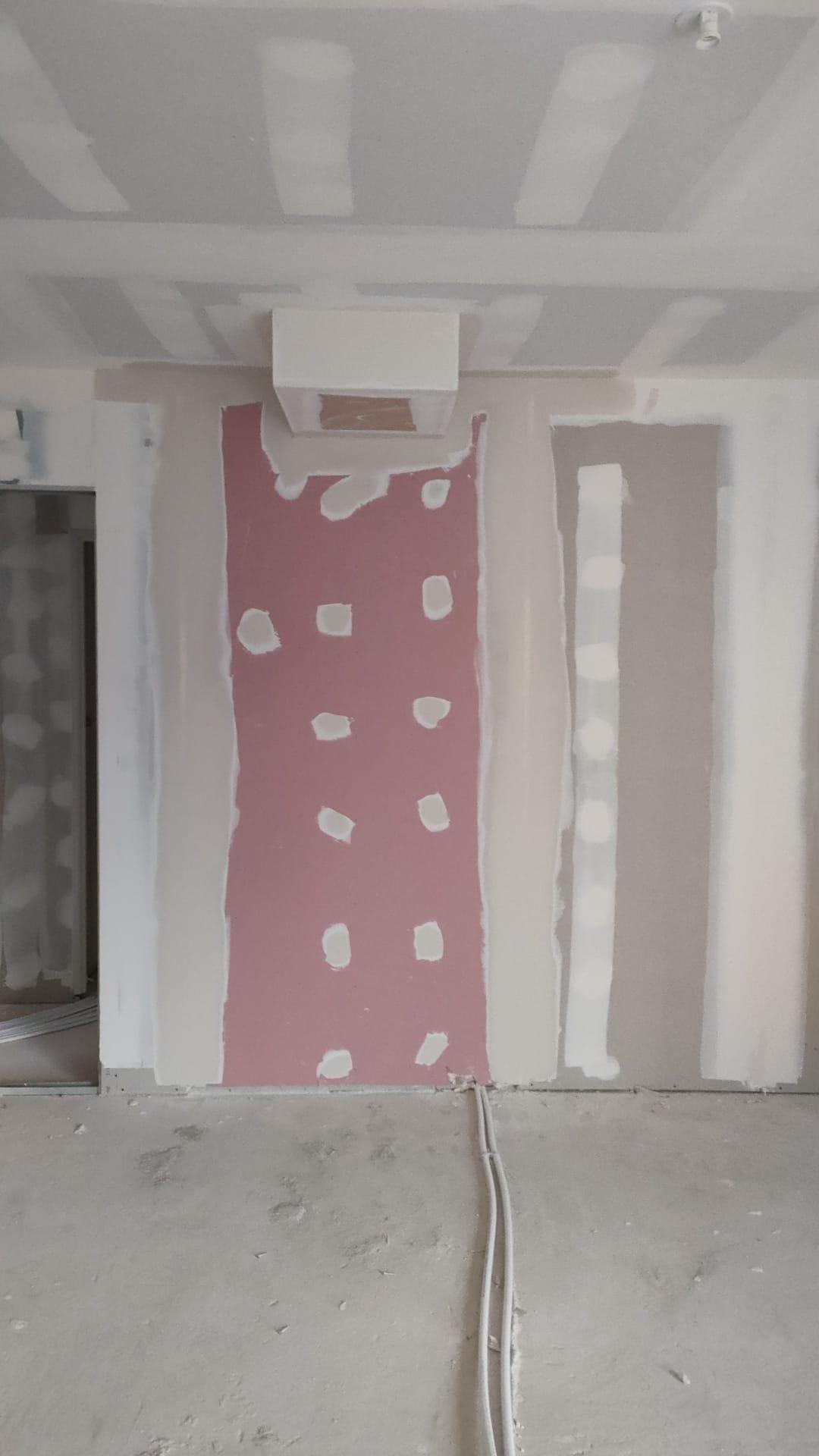 Mur et plafond en plaques de plâtre avec joints et points de fixation enduits.